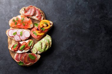 Brushetta veya geleneksel İspanyolca tapas. Meze İtalyan antipasti aperatifler ahşap tahta üzerinde ayarlayın. Üstten görünüm ve düz lay kopya alanı ile