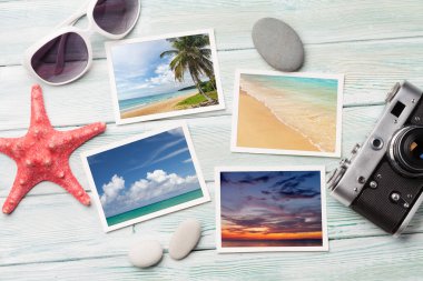 Seyahat tatil kavramı ile güneş gözlüğü, kamera ve hafta sonu fotoğraflar ahşap zemin üzerinde. Üstten görünüm. Düz yatıyordu. Bana tarafından çekilen tüm fotoğrafları