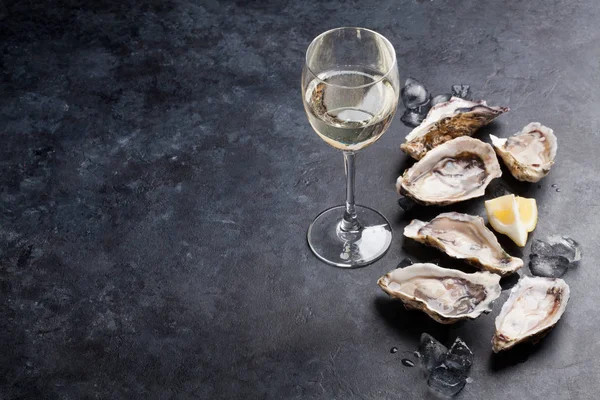 打开牡蛎 冰和柠檬 石桌上有白葡萄酒 具有复制空间 — 图库照片