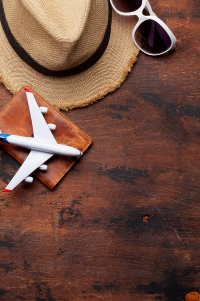 Travel vacation background concept with sun hat, passport, airplane toy and sunglasses on wooden backdrop. Top view with copy space. Flat lay