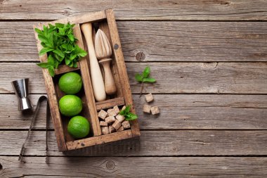 Mojito kokteyl malzemeler ve bar aksesuarları kutusu ahşap masa üzerinde. Kopya alanı ile üstten görünüm