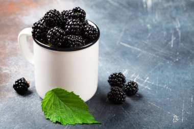 Taş masada olgun böğürtlen fincan. Senin metin için ile yer