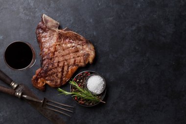 Izgara T-Bone biftek ve kırmızı şarap cam taş masada. Kopya alanı ile Üstten Görünüm