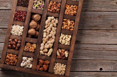 Çeşitli fındık seçim: fıstık, fındık, kestane, ceviz, Antep fıstığı ve pecans ahşap kutusunda. Metin alanı olan üstten görünüm