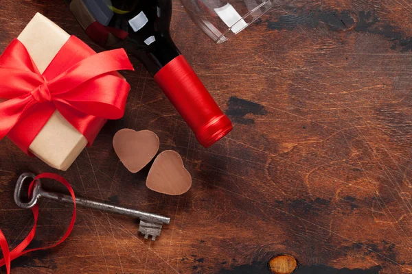 ワインのボトル チョコレートの心 キーとギフト ボックスの木製の背景でバレンタインデーのグリーティング カード あなたの挨拶のためのスペースの平面図です フラットを置く — ストック写真