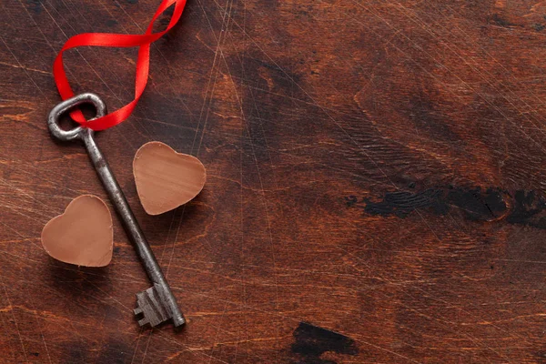鍵とチョコレートの心の木製の背景にバレンタインデーのグリーティング カード あなたの挨拶のためのスペースのトップ ビュー — ストック写真