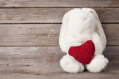 Sevgililer günü tebrik kartı kalpli hediye ve tavşan oyuncak ahşap duvar önünde şeklinde. Selam ile alan