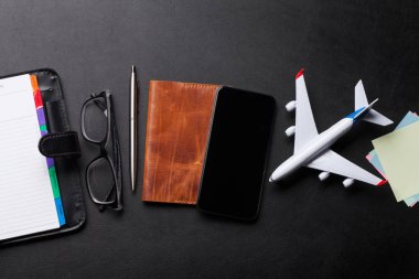 İş gezisi kavramı. Resepsiyon masasında aksesuarları. Gözlük, pasaport, Not defteri, smartphone ve uçak oyuncak. Kopya alanı ile üstten görünüm
