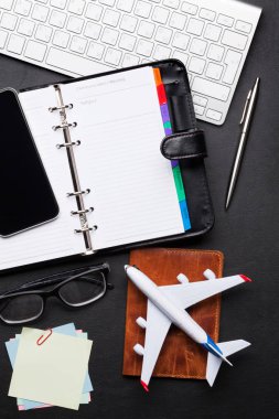 İş gezisi kavramı. Resepsiyon masasında aksesuarları. PC klavye, pasaport, Not defteri, smartphone ve uçak oyuncak. Kopya alanı ile üstten görünüm