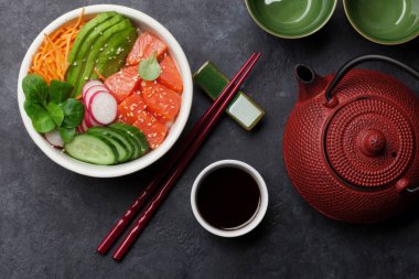 Somon ve sebzeler, Çaydanlık ve bardak ile poke kase. Geleneksel Hawaii çiğ balık salata. Üstten görünüm