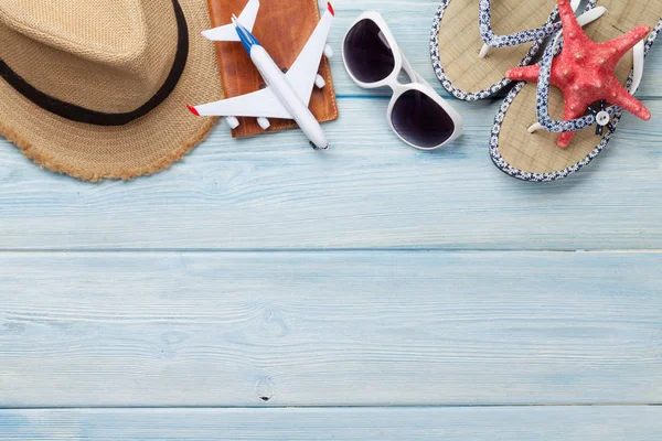 Travel vacation background concept with sun hat. sunglasses, passport, airplane toy and starfish on wooden backdrop. Top view with copy space. Flat lay