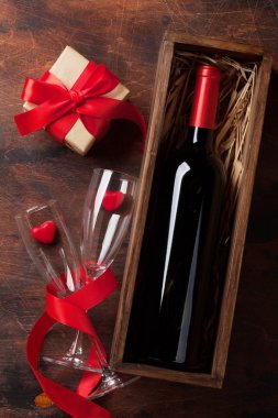 Sevgililer günü tebrik kartı ile kırmızı şarap şişe ve sevgi hediye kutusu ahşap arka plan üzerinde. Üstten görünüm. Düz yatıyordu