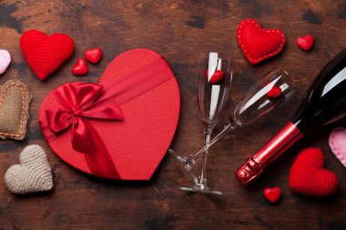 Sevgililer günü tebrik kartı kalpli hediye kutusu ve şampanya ahşap arka plan üzerinde şekillendiriyor. Üstten görünüm ile selam alan. Düz yatıyordu