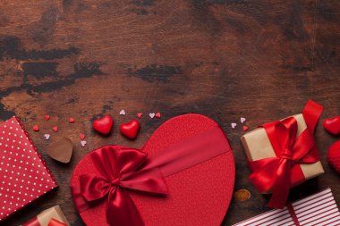 Sevgililer günü tebrik kartı ile kalp hediye kutusu ahşap arka plan üzerinde. Üstten görünüm ile selam alan. Düz yatıyordu