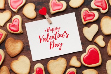 Sevgililer günü tebrik kartı kalpli kurabiye ahşap arka plan üzerinde şeklinde. Üstten görünüm ile selam alan. Düz yatıyordu