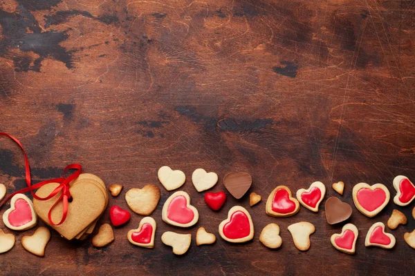 情人节贺卡与心形饼干和糖果在木背景 顶部视图与空间为您的问候 — 图库照片
