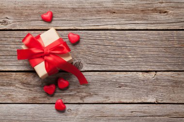 Sevgililer günü tebrik kartı ahşap arka plan üzerinde hediye kutusu ve şeker yürekleri