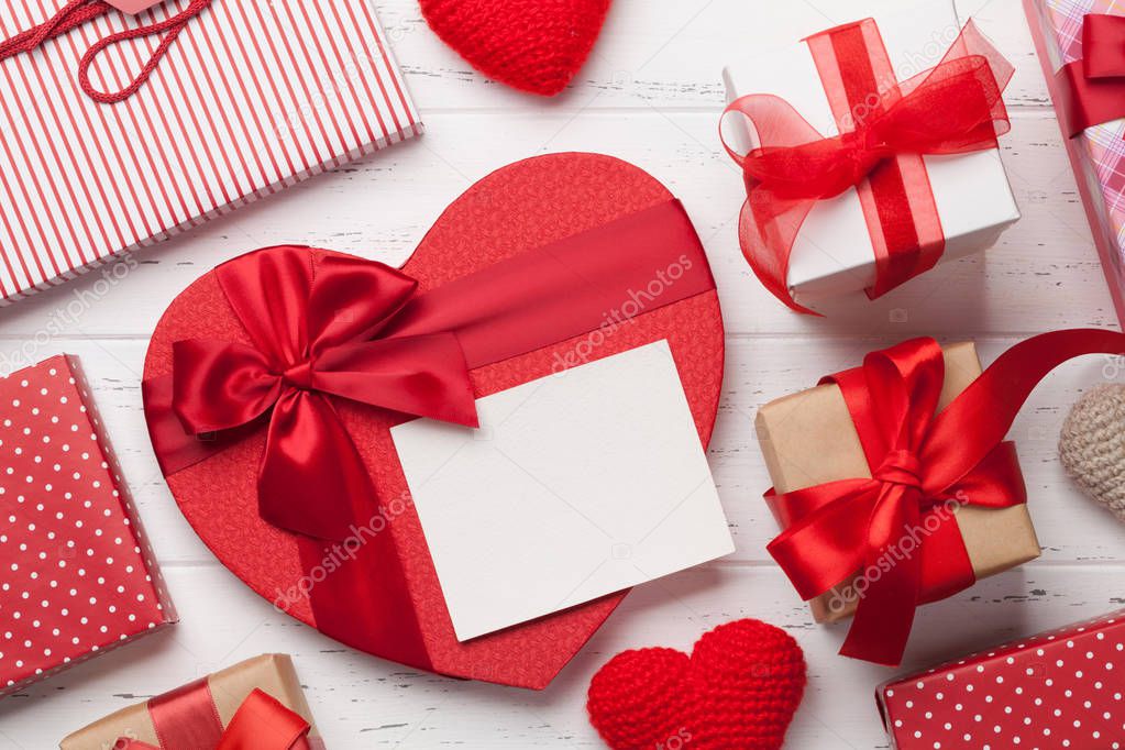 Valentine's day greeting card with handmaded heart toys and love gift boxes on wooden background