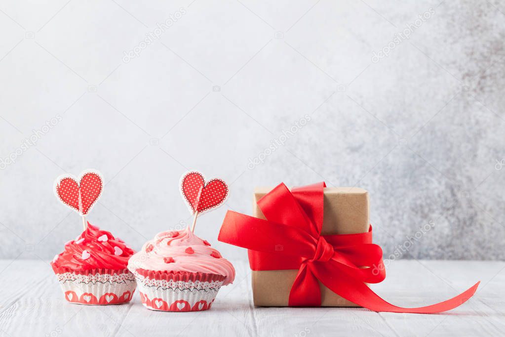 Valentine's day greeting card with delicious sweet cupcakes on stone background