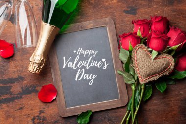 Sevgililer günü tebrik kartı ile ahşap arka plan üzerinde kırmızı gül çiçekler Buket