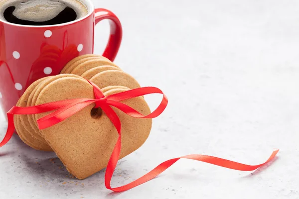 コーヒー カップと心のバレンタインのグリーティング カードの石の背景にクッキーを形作りました あなたの挨拶のためのスペースと — ストック写真