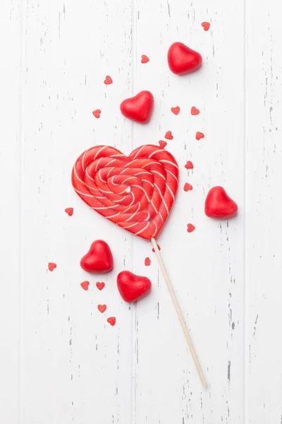 木製の背景にお菓子とバレンタインのグリーティング カード トップ ビュー — ストック写真