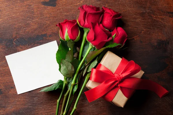 木製の背景に赤いバラの花束 ギフト ボックスとバレンタインのグリーティング カード あなたの挨拶のためのスペースのトップ ビュー — ストック写真