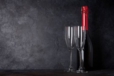 Şampanya şişesi ve taş duvar önünde bardak. Senin metin için ile yer