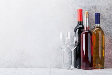 Kırmızı, gül ve beyaz şarap şişesi ve gözlük taş duvar önünde. Senin metin için ile yer