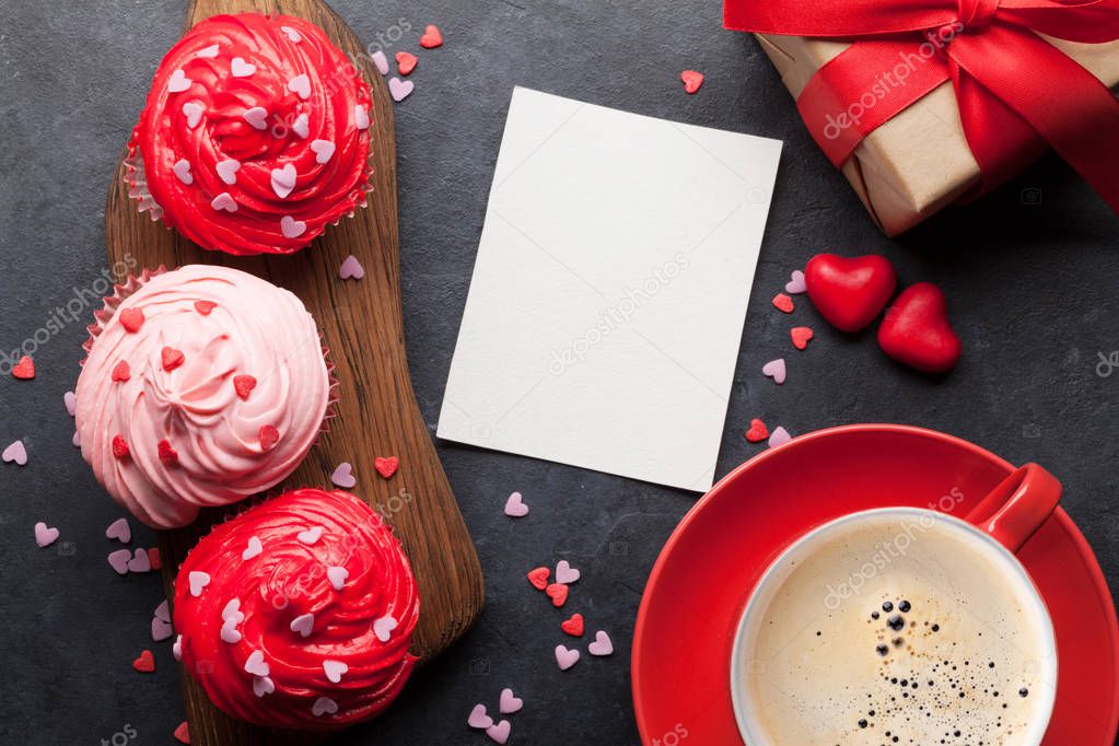 Valentine's day greeting card with delicious sweet cupcakes on stone background