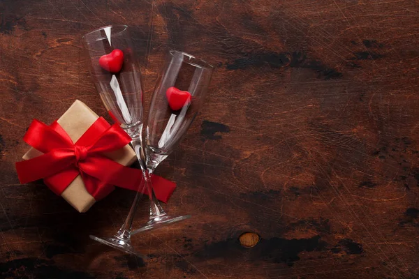 情人节贺卡与香槟眼镜 糖果心和礼品盒的木制背景 为您的问候语提供空间的顶视图 — 图库照片