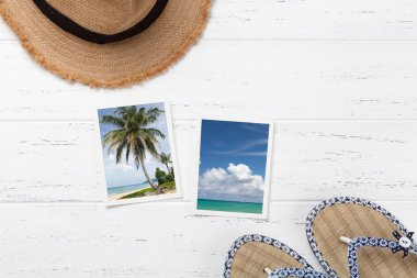 Ahşap masa üzerinde flip flop ve yaz fotoğraf, tatil arka plan kavramı plaj şapka ile seyahat. Üstten Görünüm kopya alanı ile. Düz yatıyordu. Bana tarafından çekilen tüm fotoğrafları