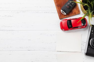 Seyahat tatil konseptiyle kamera, pasaport, araba oyuncak ve fotoğraf çerçeveleri ahşap zemin üzerinde. Üstten Görünüm kopya alanı ile. Düz yatıyordu