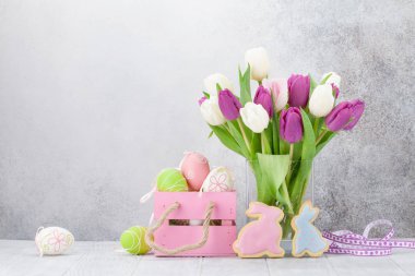 Lale çiçek buketi ve Paskalya yumurta Paskalya tebrik kartı. Selam yeri olan taş duvarın önünde