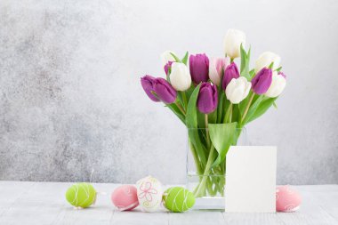 Lale çiçek buketi ve Paskalya yumurta Paskalya tebrik kartı. Selam yeri olan taş duvarın önünde