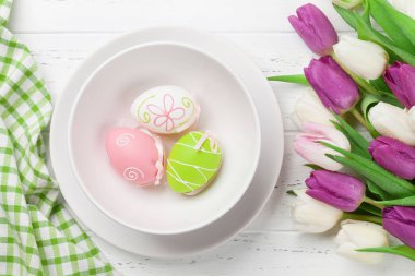 Lale çiçek buketi ve Paskalya yumurta Paskalya tebrik kartı. Beyaz ahşap masa üzerinde Üstten Görünüm