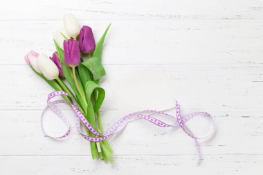 Lale çiçek kokulu beyaz ahşap zemin üzerinde paskalya tebrik kartı