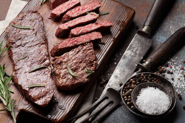 Top blade or denver grilled steak over cutting board