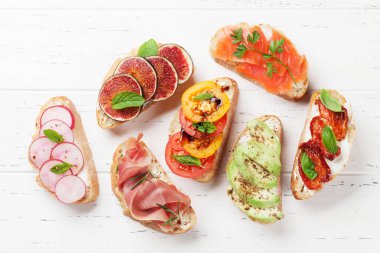 Brushetta veya geleneksel İspanyolca tapas. Meze İtalyan antipasti aperatifler ahşap tahta üzerinde ayarlayın. Üstten görünüm ve düz lay