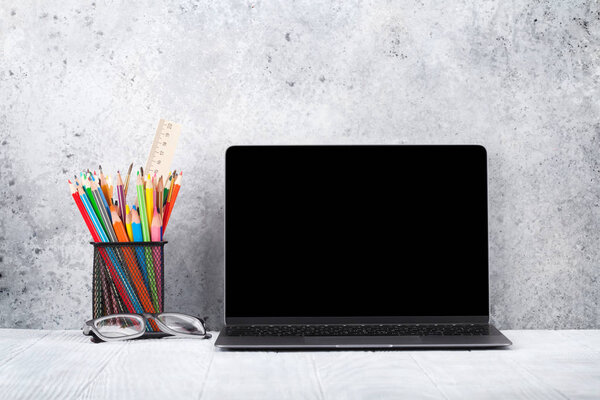 Лофт домашнего офиса рабочее место с Blank черный экран ноутбук и аксессуары. С копировальным местом для макета или текста
