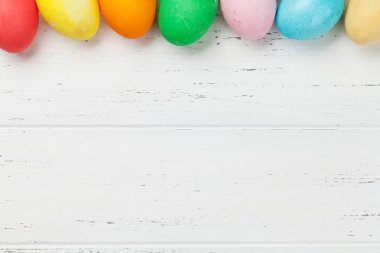 Renkli yumurta Paskalya tebrik kartı. Selam yeri olan ahşap masa üzerinde Üstten Görünüm