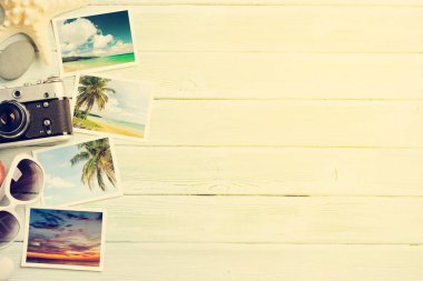 Seyahat tatil arka plan kavramı ile güneş gözlüğü, kamera ve hafta sonu fotoğraflar ahşap zemin üzerinde. Üstten görünüm kopya alanı ile. Düz yatıyordu. Bana tarafından çekilen tüm fotoğrafları. Sunny tonda