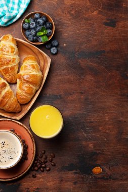 Kahve, kruvasan, portakal suyu ve çilek kahvaltı. Ahşap masa üzerinde. Metniniz için kopya alanı ile Üstten Görünüm