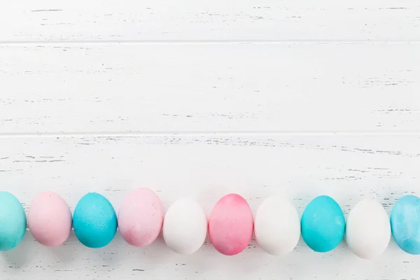 Ostergrüßkartenhintergrund Mit Bunten Eiern Auf Weißem Holztisch Draufsicht Mit Platz — Stockfoto