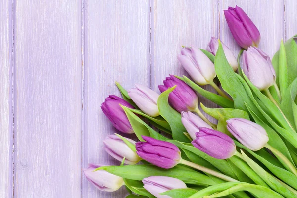 Фиолетовые тюльпаны на деревянном столе — стоковое фото