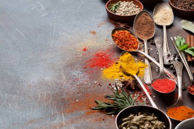 Kaşık ve baharatlar ve otlar taş zemin üzerine kase kümesi. Üstten Görünüm 