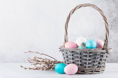Kukum dal ve taş duvar önünde sepetteki renkli Paskalya yumurtaları Paskalya tebrik kartı 