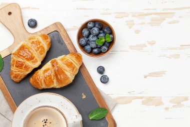 Kahve kruvasan ve ahşap masa üzerinde meyveleri. Üstten Görünüm, Kahvaltı konsepti 