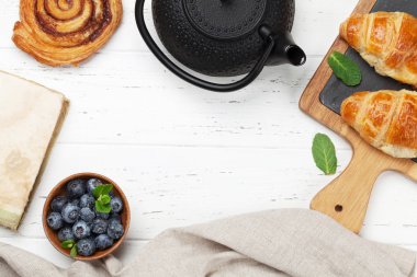 Çay kruvasan ve tarçın ile ahşap masa üzerinde meyveleri ile rulo. Üstten Görünüm, Kahvaltı konsepti 