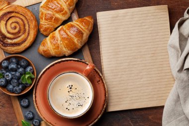 Kruvasan ve tarçın ile kahve meyveleri ile ahşap masanın üzerine alır. Üstten Görünüm, Kahvaltı konsepti 